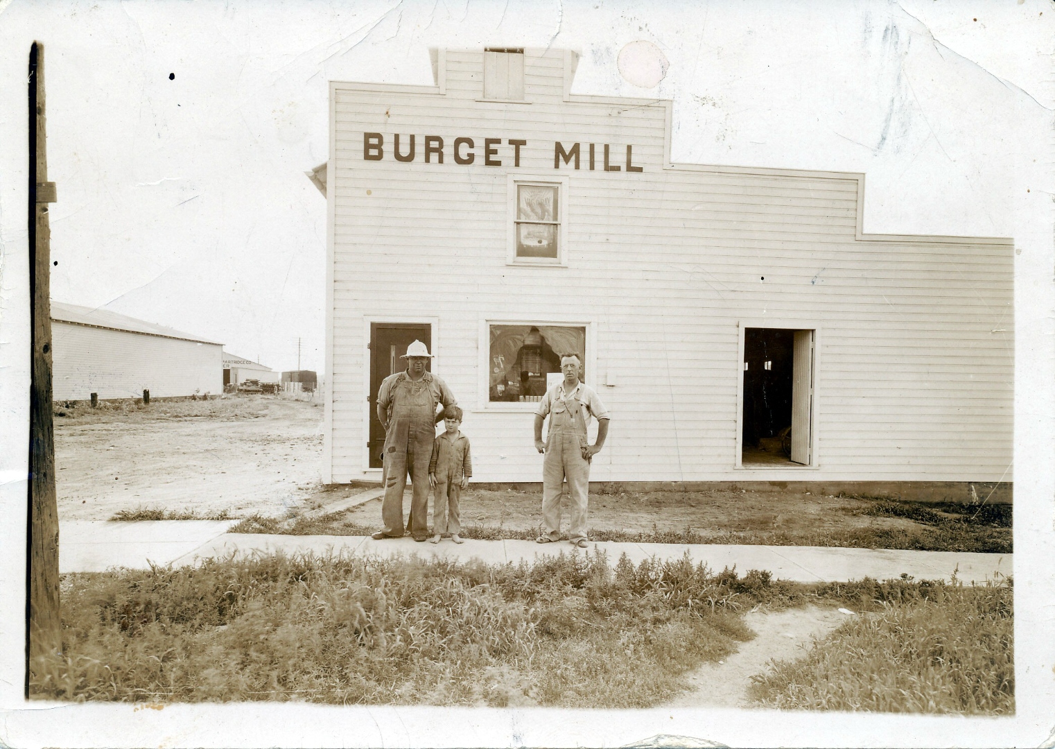The original Burget Mill building, circa 1930s, with three generations standing in front