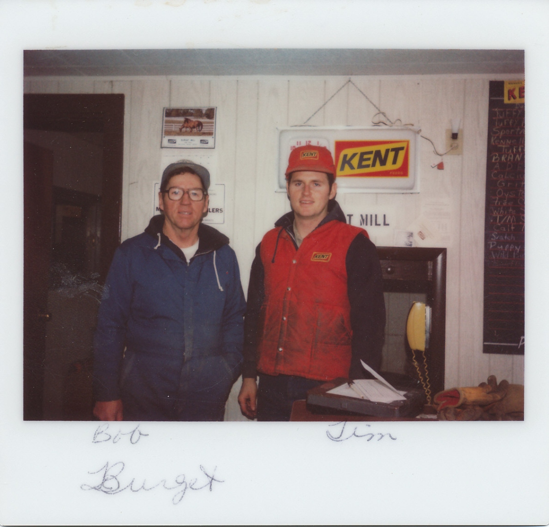 Bob and Tim Burget inside Burget Mill in the early 1970s with Kent Feeds sign